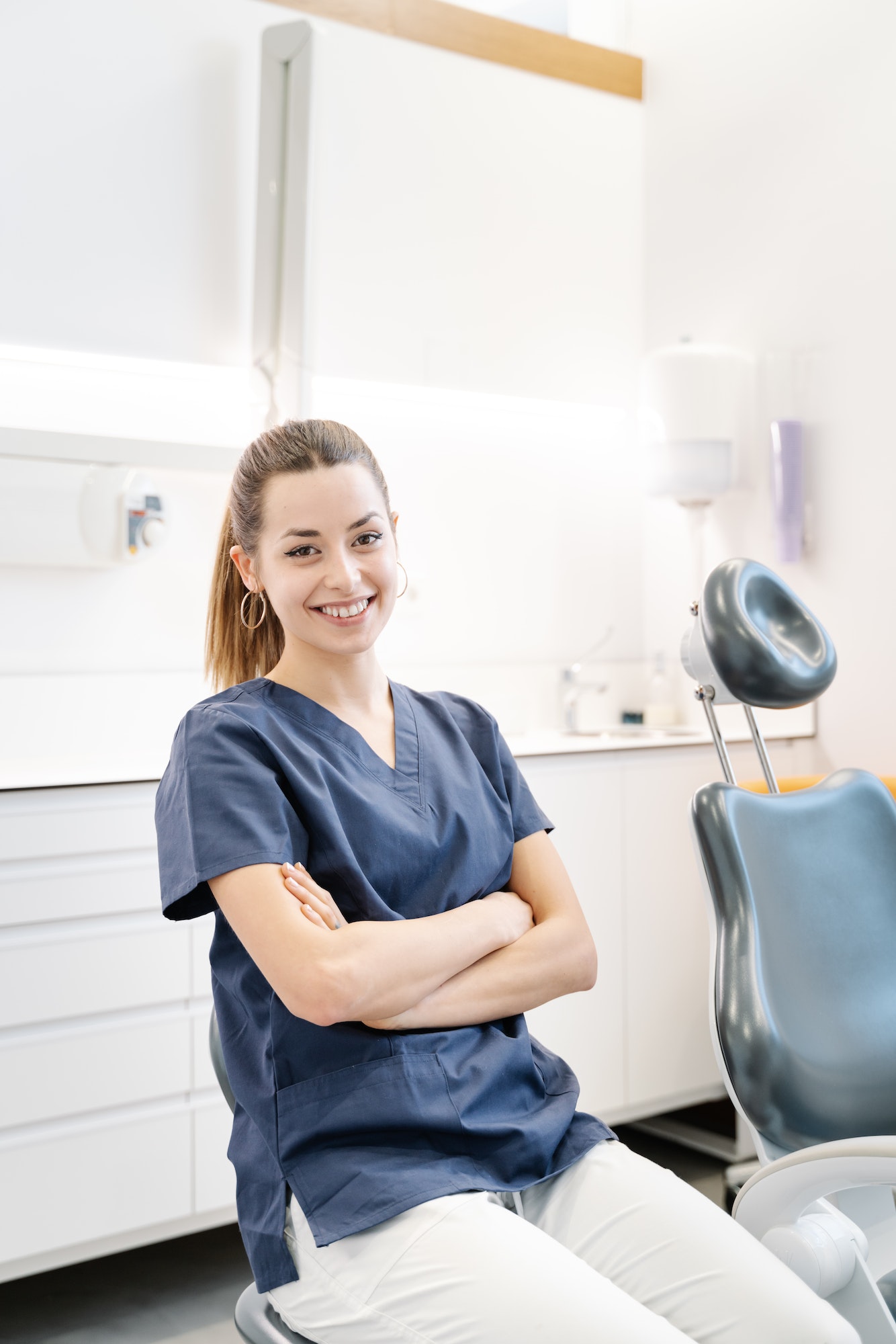 Young nurse in blue jacket smiles in the dental office before receiving the patient.